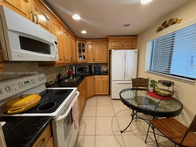 a kitchen with stainless steel appliances kitchen island granite countertop a sink a stove and a microwave