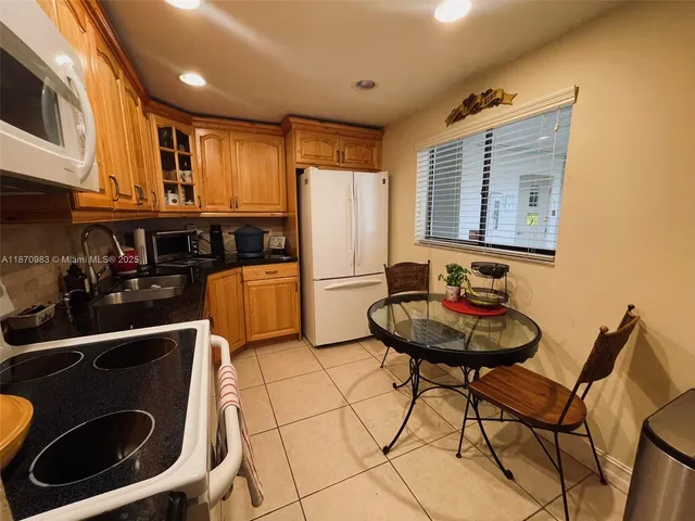 a view of a kitchen with a dining table and chairs