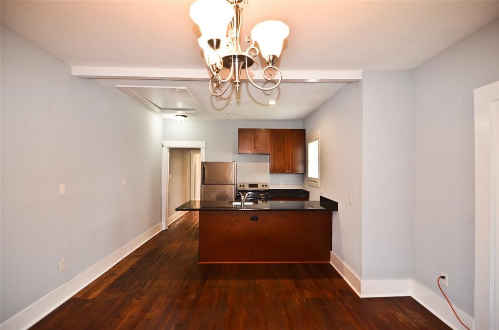 1905 Stevens Street, Unit 2 Houston, TX 77026 - Photo 7 of 22 a view of a dining room with furniture a chandelier and wooden floor