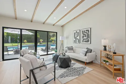a living room with furniture and a floor to ceiling window