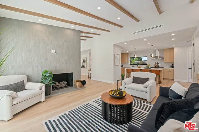 a kitchen with stainless steel appliances granite countertop a sink a stove a refrigerator and island with wooden floor