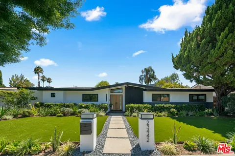 a front view of a house with a garden and yard