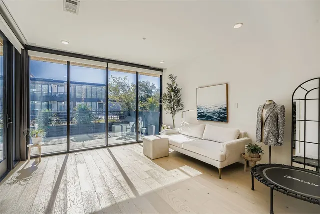 a living room with furniture and a floor to ceiling window
