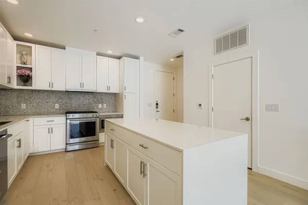 a kitchen with granite countertop white cabinets and white appliances