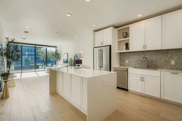 a open kitchen with white cabinets and wooden floor