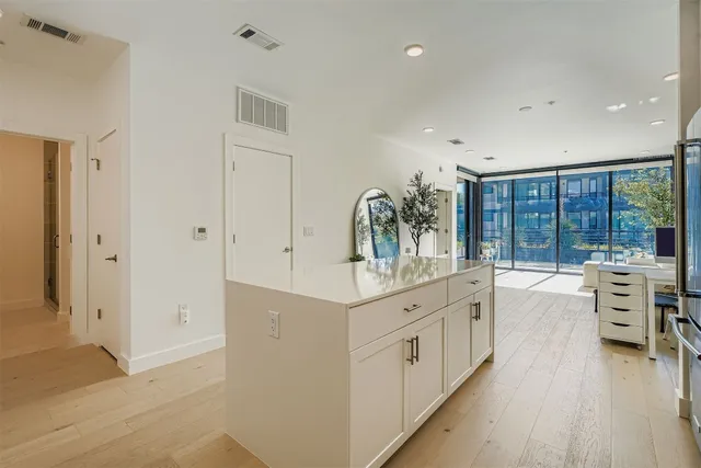 a large white kitchen with a large window and stainless steel appliances