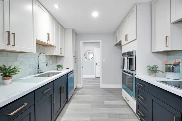 a kitchen with stainless steel appliances granite countertop a refrigerator sink and white cabinets