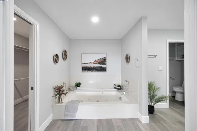 a spacious bathroom with a granite countertop sink a toilet and a mirror