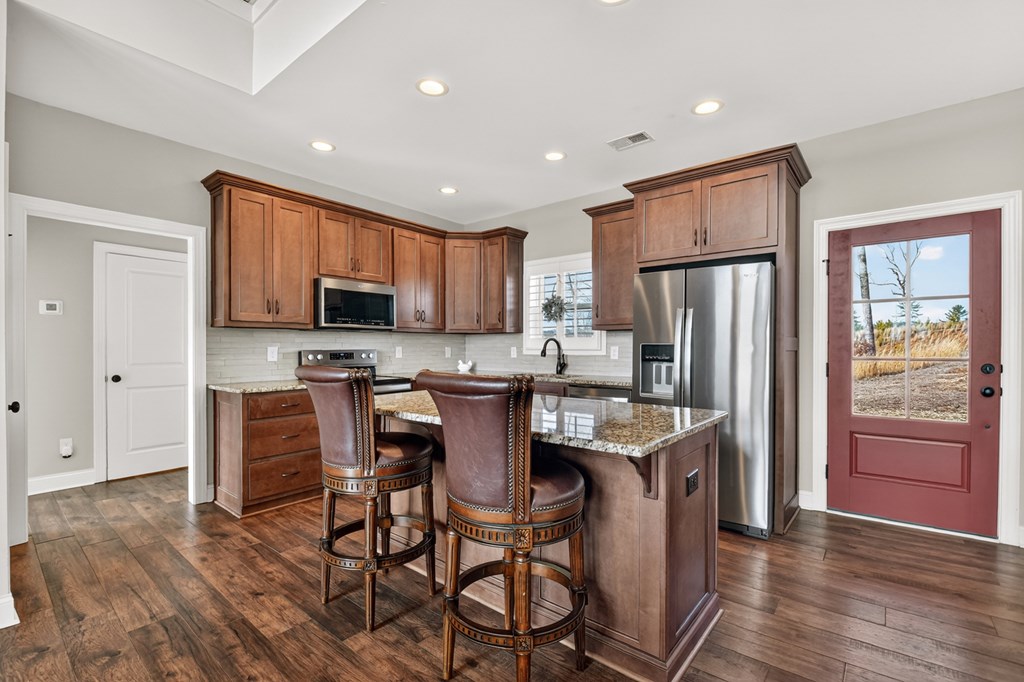 28 Mountaintown Road Ellijay, GA 30540 - Photo 14 of 54 a kitchen with stainless steel appliances granite countertop a refrigerator a stove top oven a sink dishwasher a dining table and chairs with wooden floor