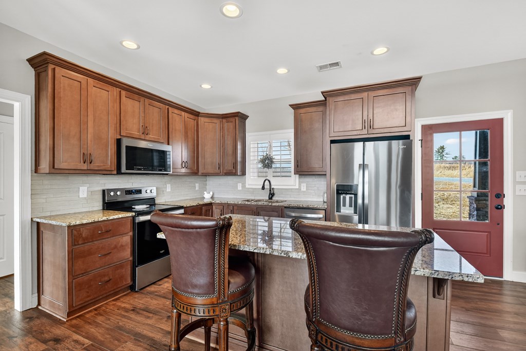 28 Mountaintown Road Ellijay, GA 30540 - Photo 15 of 54 a kitchen with stainless steel appliances granite countertop a stove a sink dishwasher a dining table and chairs