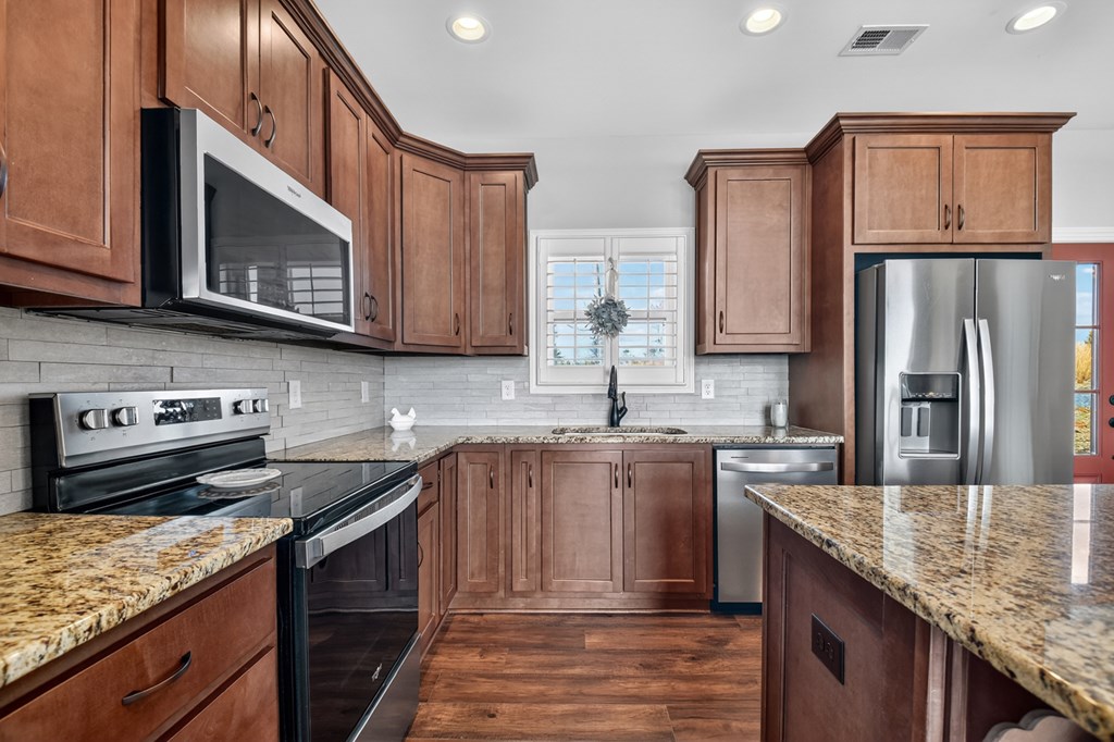 28 Mountaintown Road Ellijay, GA 30540 - Photo 16 of 54 a kitchen with stainless steel appliances granite countertop a stove microwave and refrigerator