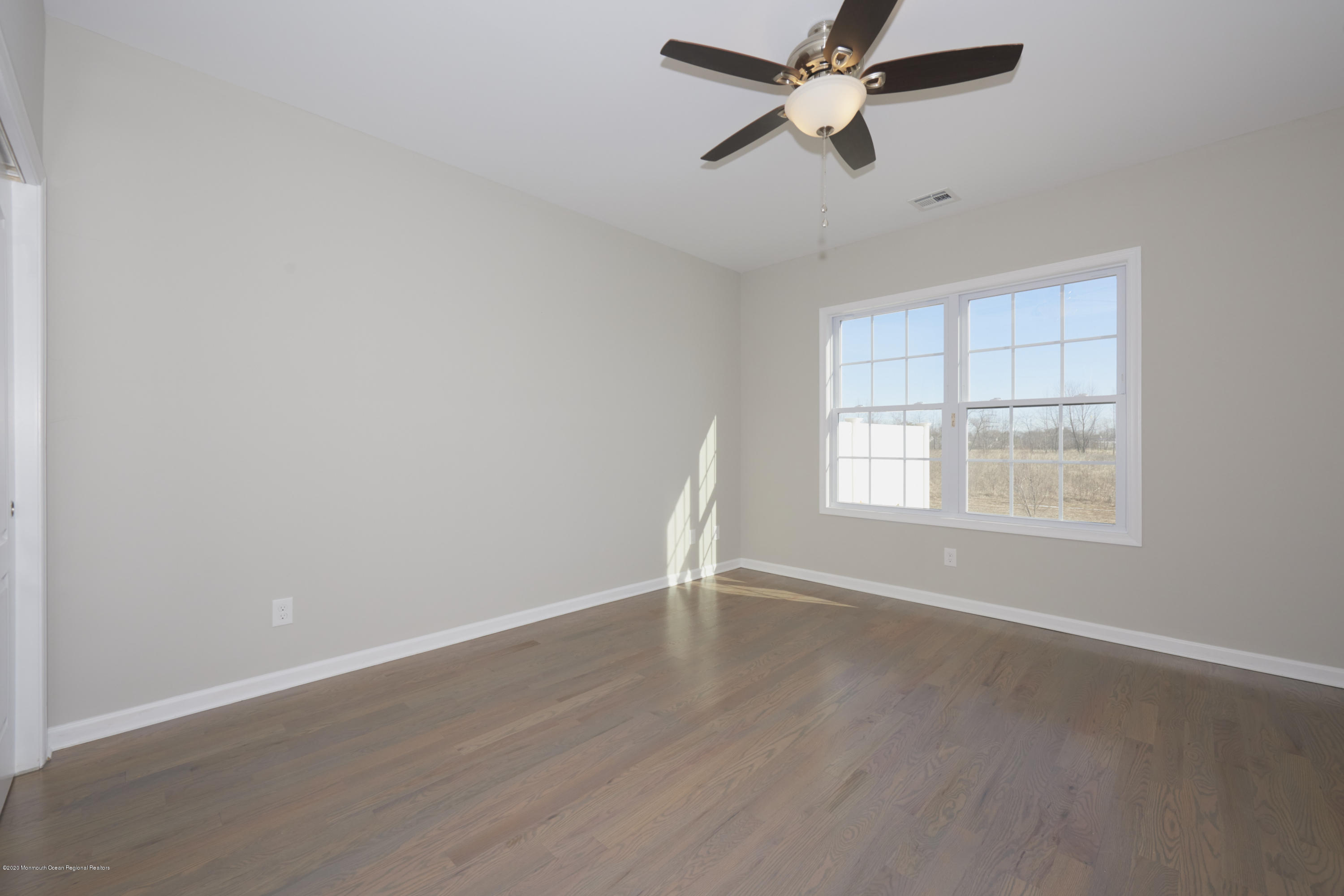 21 Green Tree Circle Hazlet, NJ 07730 - Photo 14 of 38 an empty room with wooden floor ceiling fan and windows
