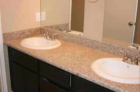 a bathroom with a granite countertop sink and a mirror