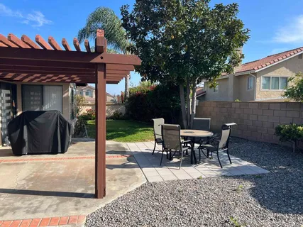 a view of a patio with table and chairs near a yard