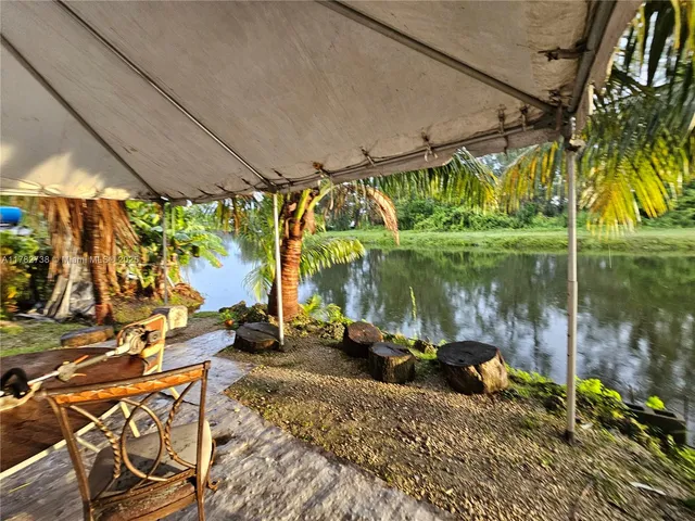 a backyard of a house with a fountain swing table and chairs