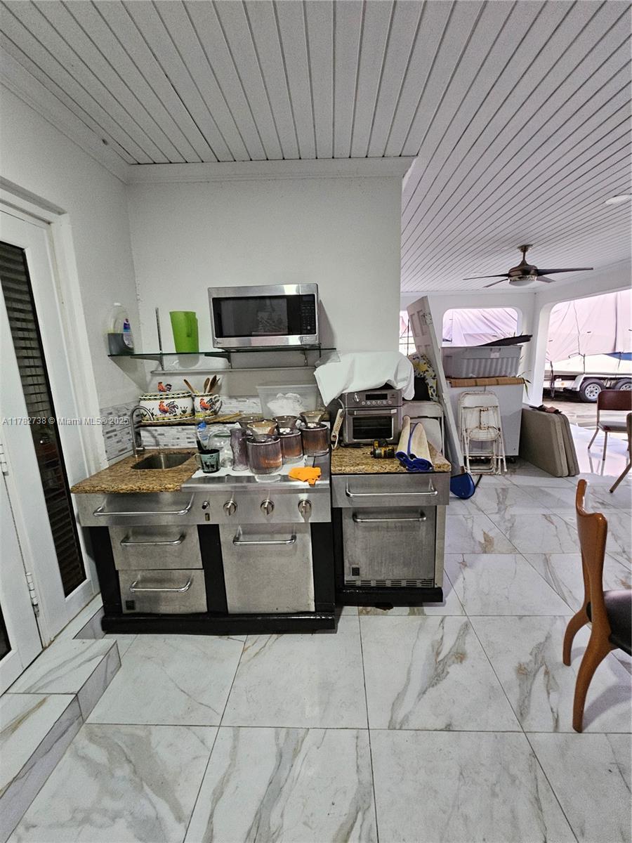 Westview Miami, FL 33167 - Photo 23 of 46 a kitchen with stainless steel appliances kitchen island granite countertop a stove a sink dishwasher and a black refrigerator