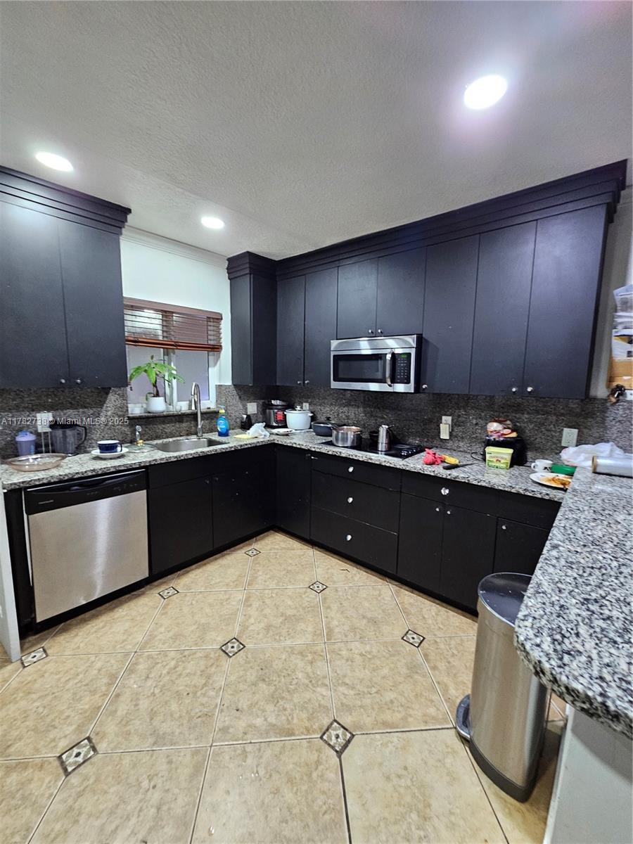 Westview Miami, FL 33167 - Photo 25 of 46 a kitchen with kitchen island granite countertop wooden cabinets a counter top space and stainless steel appliances