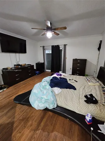 a bedroom with a bed and a flat tv screen on dresser
