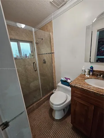 a bathroom with a granite countertop toilet sink and shower