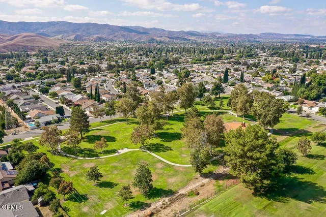 an aerial view of residential houses with outdoor space and trees