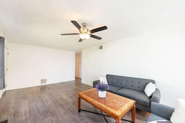 a living room with furniture and a wooden floor