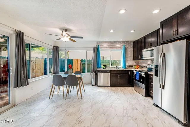 a kitchen with a table chairs refrigerator and cabinets