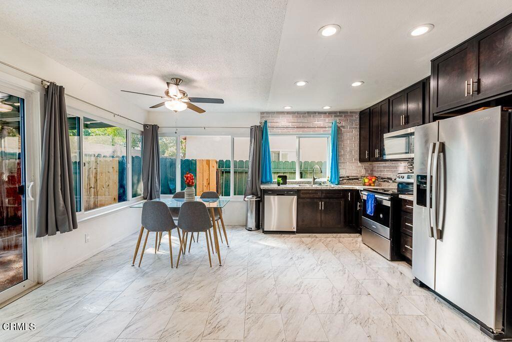 2250 North Goddard Avenue Simi Valley, CA 93063 - Photo 6 of 25 a kitchen with a table chairs refrigerator and cabinets