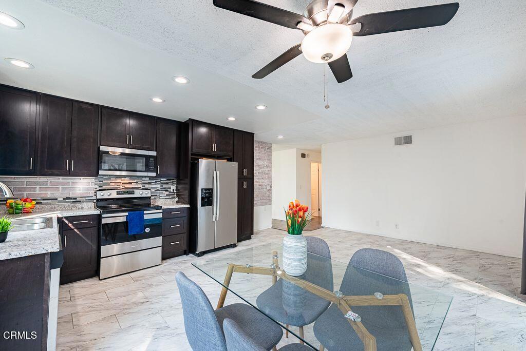 2250 North Goddard Avenue Simi Valley, CA 93063 - Photo 7 of 25 a kitchen with stainless steel appliances kitchen island granite countertop a refrigerator a stove top oven a sink with island and chairs