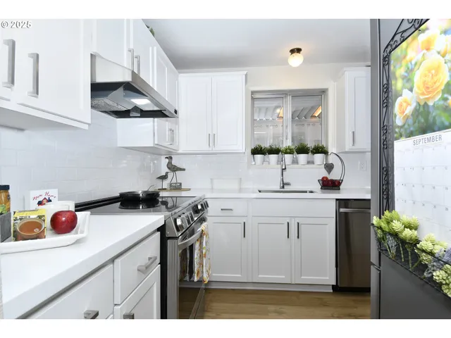 a kitchen with kitchen island granite countertop a sink a stove and cabinets