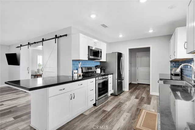a kitchen with white cabinets and stainless steel appliances