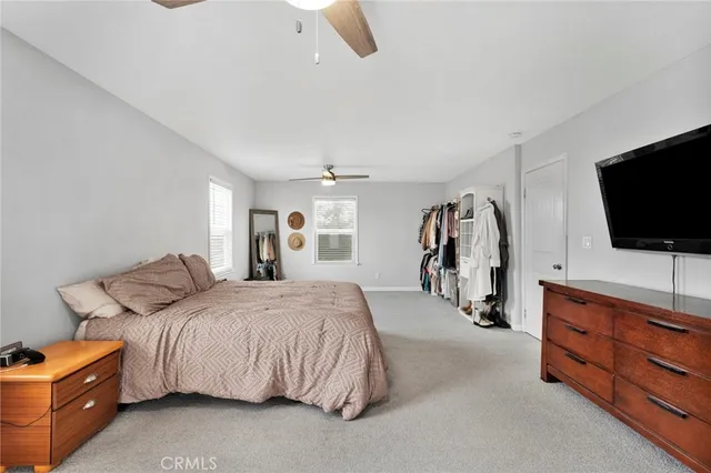 a bedroom with a bed and a flat tv screen on wall