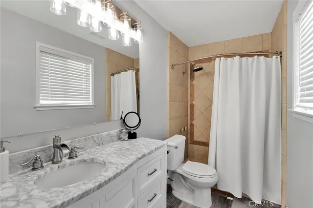 a bathroom with a granite countertop sink toilet and shower
