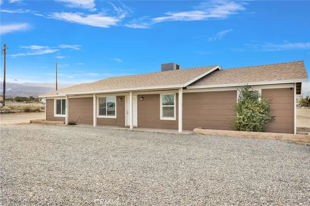 a front view of a house with a garden and yard