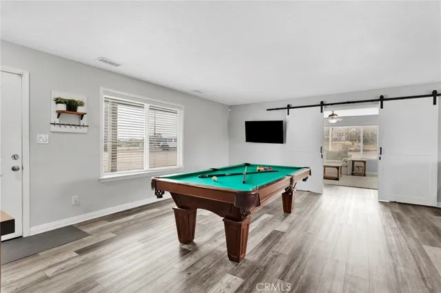 a room with furniture pool table and windows
