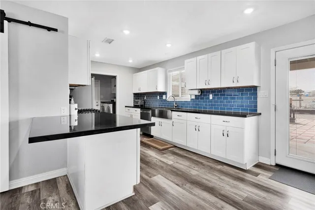 a kitchen with granite countertop a sink stainless steel appliances and cabinets