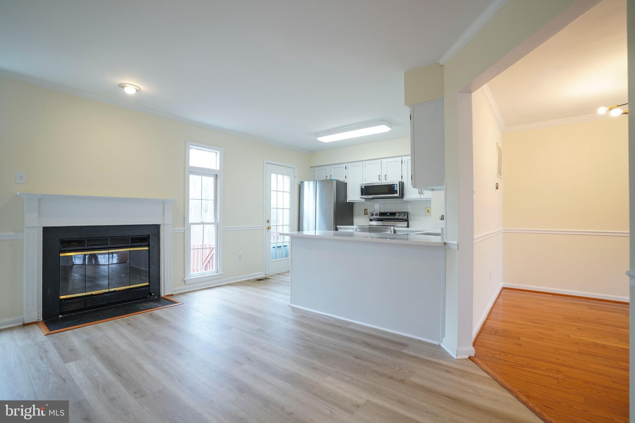 6903 Compton Lane Centreville, VA 20121 - Photo 11 of 35 a kitchen with stainless steel appliances wooden floor and a fireplace
