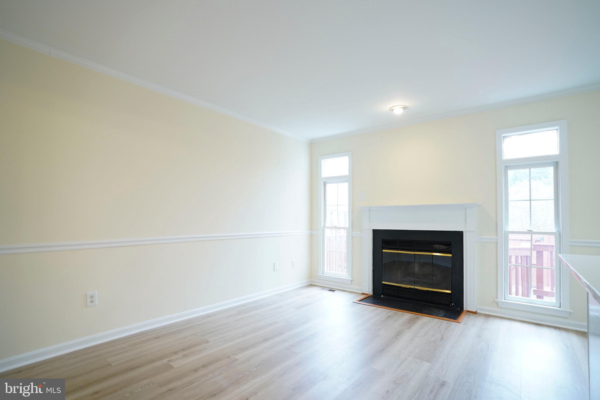 6903 Compton Lane Centreville, VA 20121 - Photo 12 of 35 an empty room with wooden floor fireplace and windows