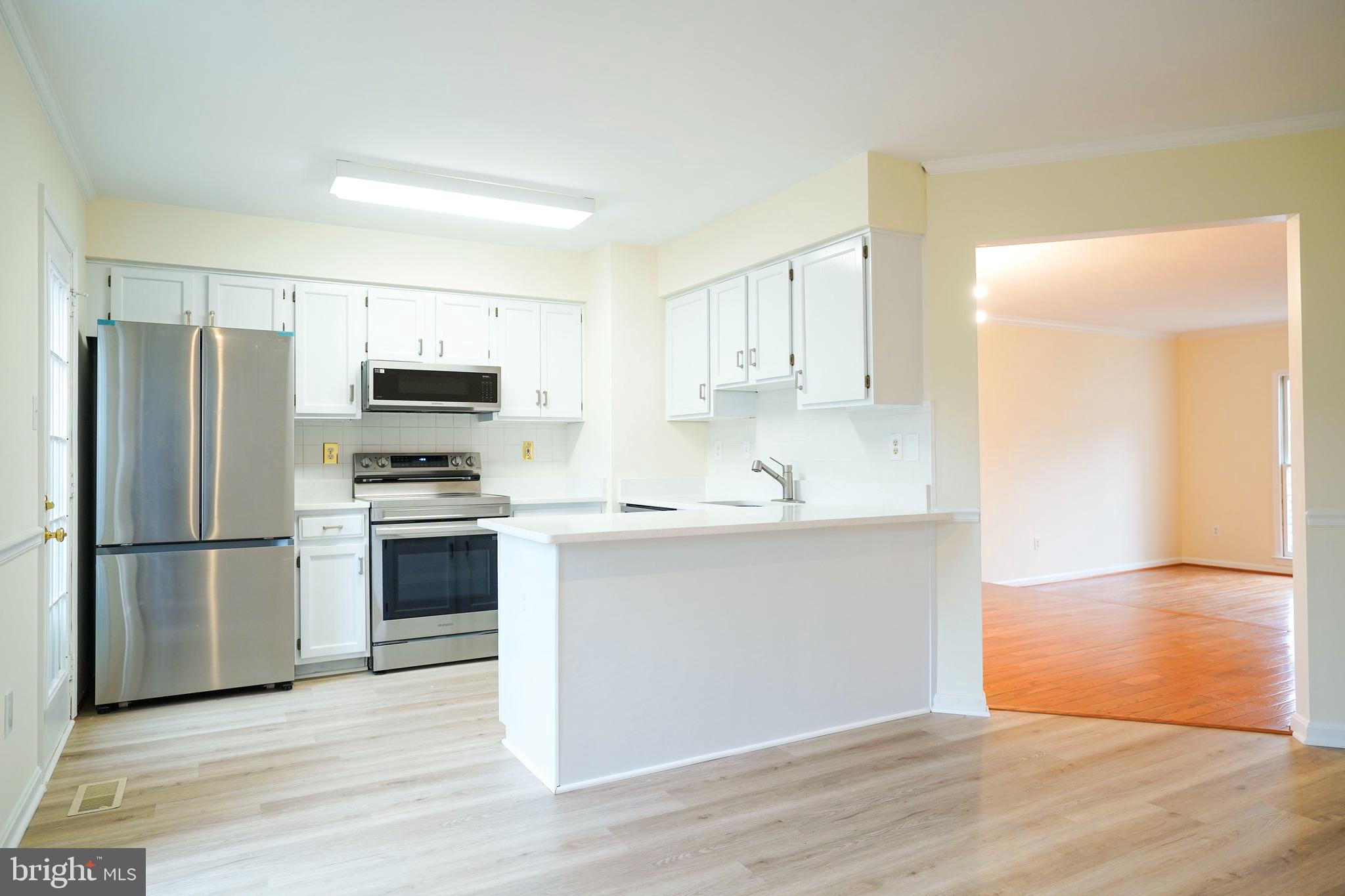 6903 Compton Lane Centreville, VA 20121 - Photo 9 of 35 a kitchen with a refrigerator cabinets and wooden floor