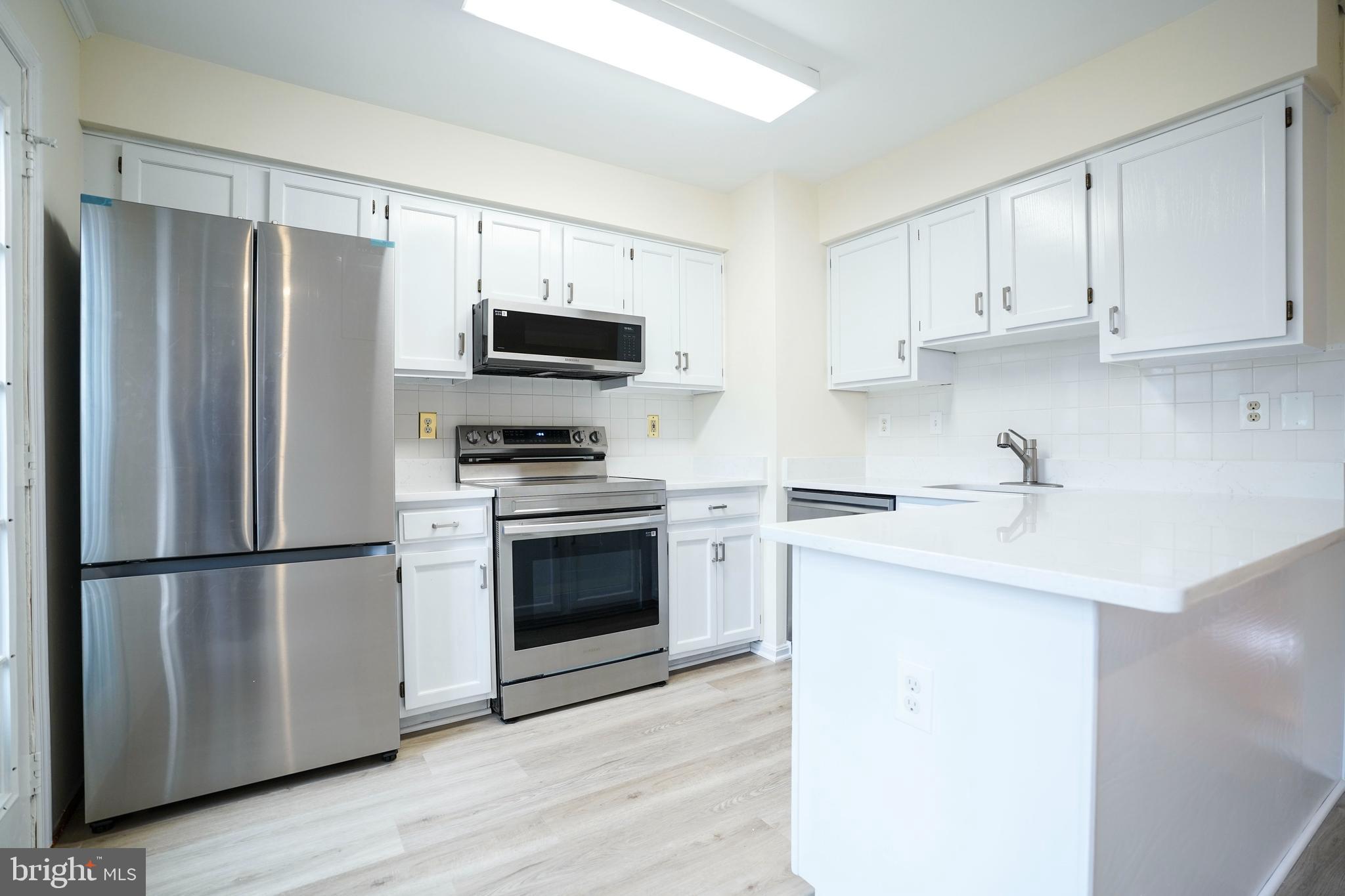 6903 Compton Lane Centreville, VA 20121 - Photo 10 of 35 a kitchen with stainless steel appliances a refrigerator sink and microwave