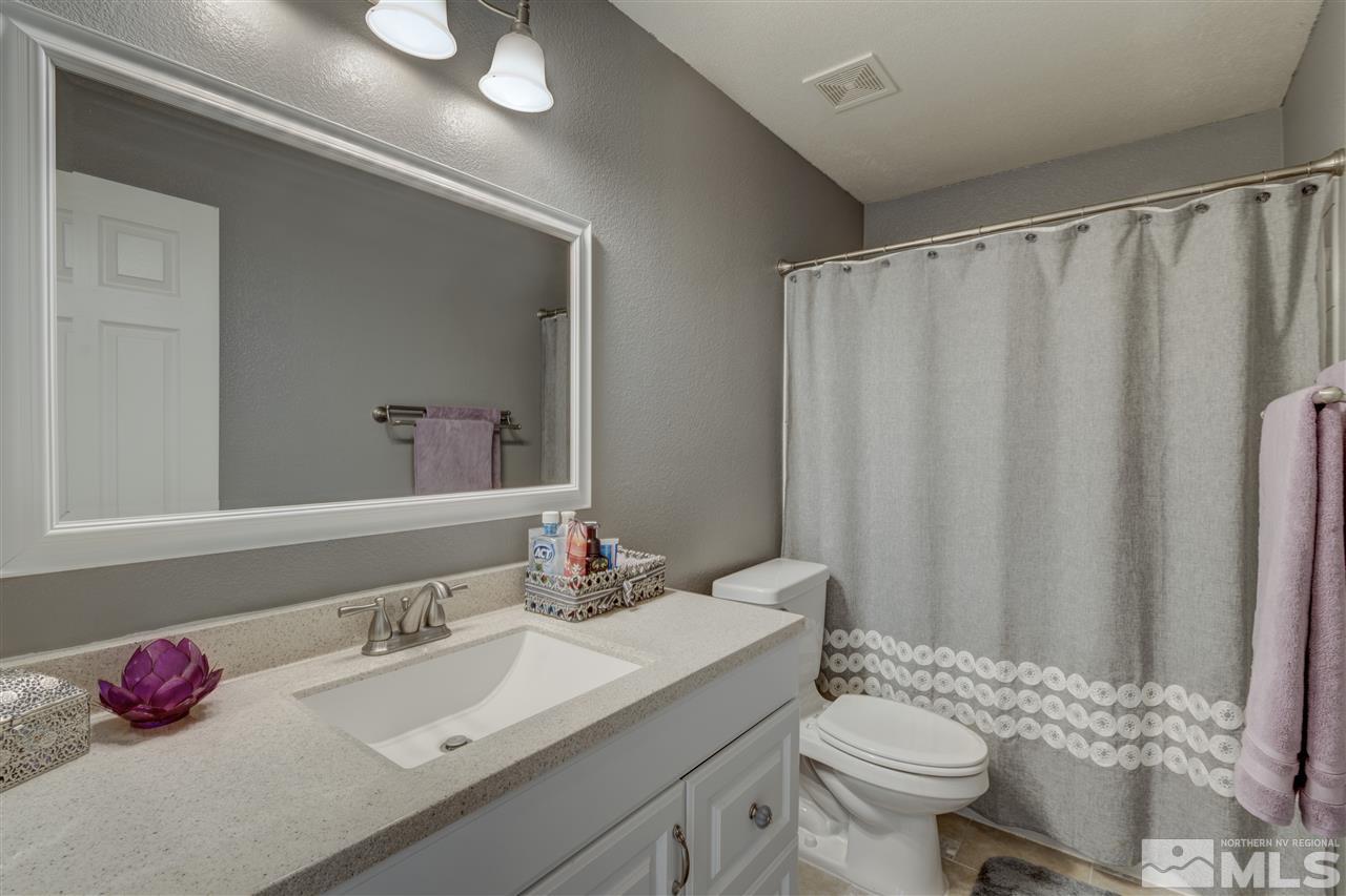 7638 Corso Street Reno, NV 89506 - Photo 18 of 29 a bathroom with a sink vanity mirror and toilet
