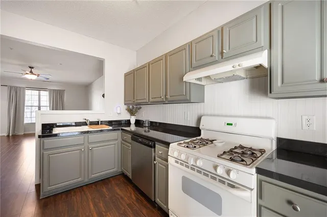 a kitchen with stainless steel appliances a stove a sink and cabinets
