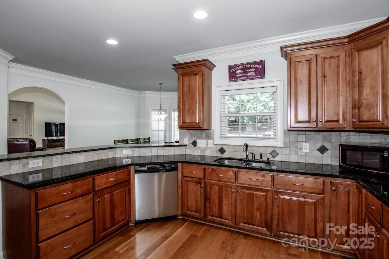 3545 Maple Brook Drive Denver, NC 28037 - Photo 17 of 40 a kitchen with stainless steel appliances granite countertop wooden cabinets a sink and dishwasher with wooden floor