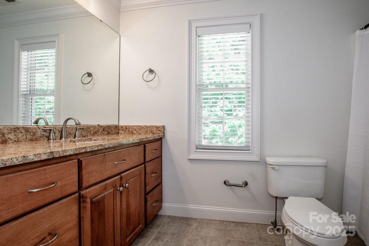 3545 Maple Brook Drive Denver, NC 28037 - Photo 26 of 40 a bathroom with a granite countertop toilet a sink a mirror and a window