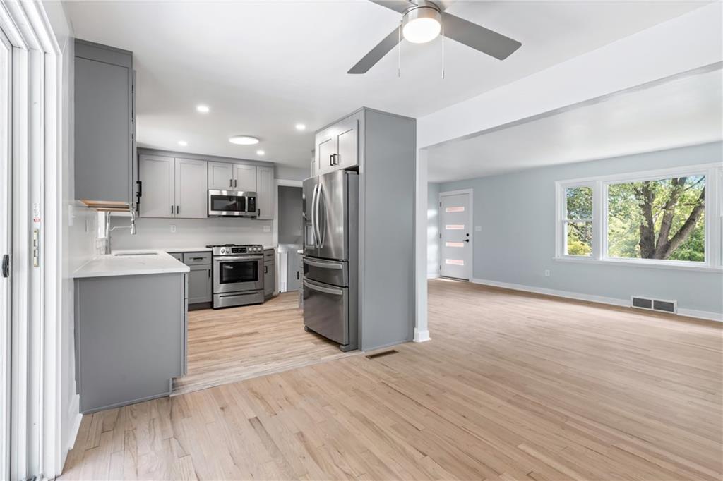 4030 Circle Drive Allison Park, PA 15101 - Photo 12 of 41 a kitchen with stainless steel appliances kitchen island granite countertop a refrigerator a stove top oven a sink and dishwasher with wooden floor