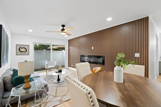 a living room with furniture a potted plant and a wooden floor