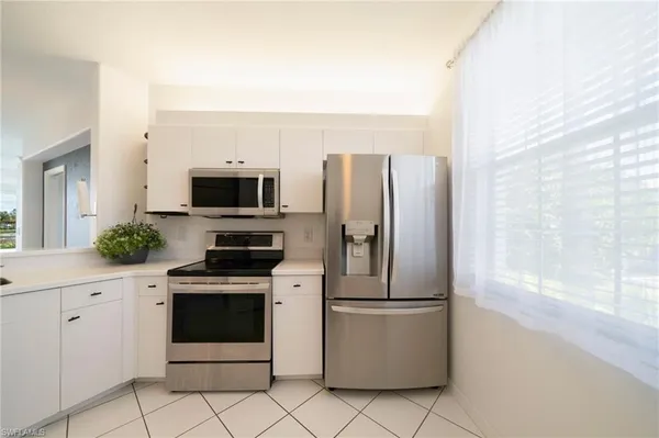 a kitchen with appliances a sink and cabinets