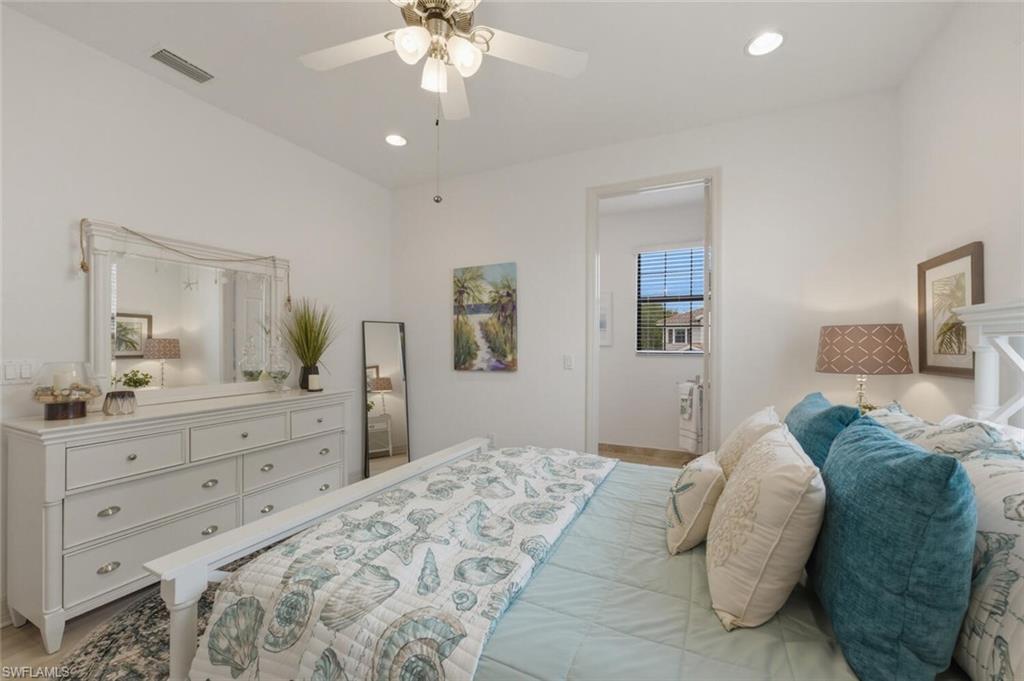 3306 Baltic Drive Naples, FL 34119 - Photo 28 of 49 a bedroom with a large bed and a chandelier