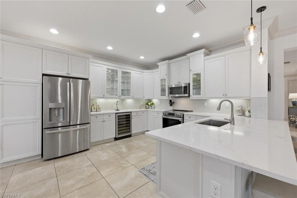 3306 Baltic Drive Naples, FL 34119 - Photo 3 of 49 a kitchen with a refrigerator sink and wooden cabinets