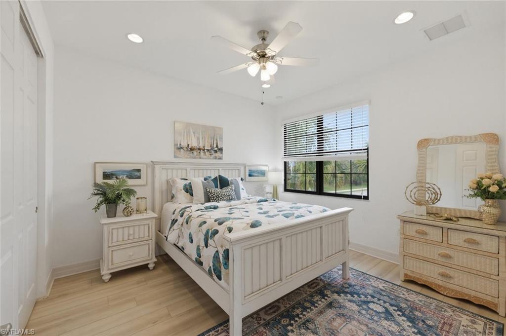 3306 Baltic Drive Naples, FL 34119 - Photo 33 of 49 a bedroom with a bed and a chandelier