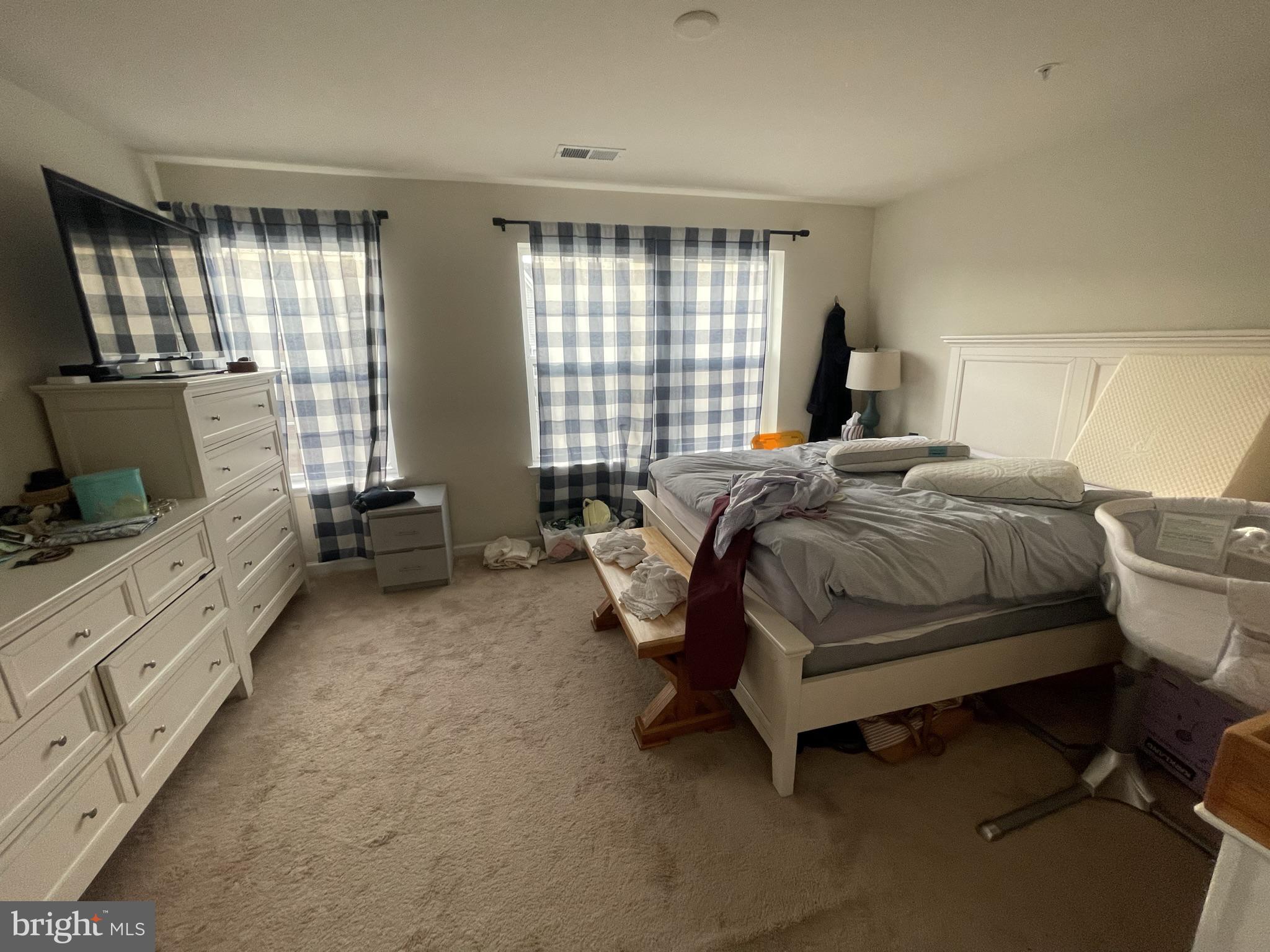 7563 Crowley Street Hanover, MD 21076 - Photo 7 of 15 a spacious bedroom with a bed and a flat screen tv